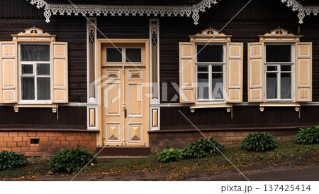 Traditional Wooden House Facade with Ornate Windows and Door Traditional Wooden House Facade with Ornate Windows and Door 137425414