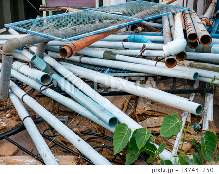 Stack of Used White and Blue PVC Pipes with Rusty Metal Pipes Stack of Used White and Blue PVC Pipes with Rusty Metal Pipes 137431250