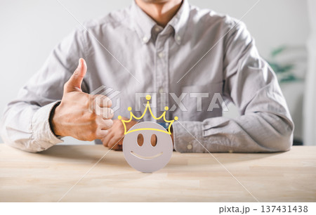 Customer gives thumbs up to crowned happy face, indicating positive feedback, satisfaction with online service experience, excellent quality rating for business review concept 137431438