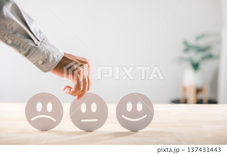 Customer provides satisfaction feedback on service quality, hand selecting emoticon for experience survey concept, offering important rating data aiding business growth Customer provides satisfaction feedback on service quality, hand selecting emoticon for experience survey concept, offering important rating data aiding business growth 137431443