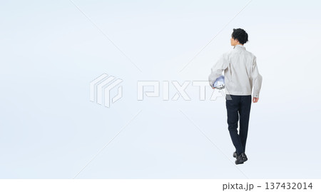 ヘルメットを持って歩く作業服の男性の後ろ姿の全身写真 137432014