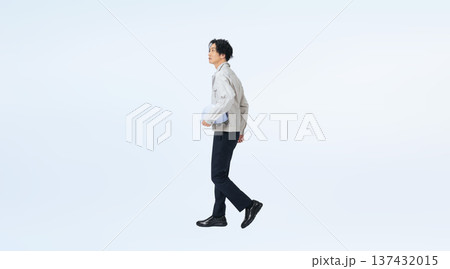 ヘルメットを持って歩く作業服の男性の全身写真 ヘルメットを持って歩く作業服の男性の全身写真 137432015