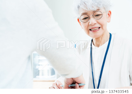 相談を受けるシニア女性 相談を受けるシニア女性 137433545