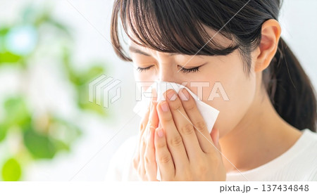 ティッシュで鼻をかむ若い女性 花粉症や風邪の症状 137434848