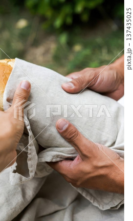 Hands Passing Fresh Bread Wrapped in Linen Cloth Hands Passing Fresh Bread Wrapped in Linen Cloth 137435025