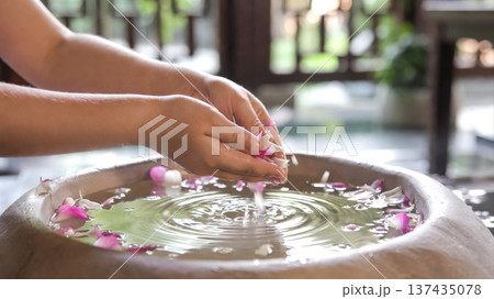 Hands Releasing Flower Petals Into Spa Water Bowl Hands Releasing Flower Petals Into Spa Water Bowl 137435078