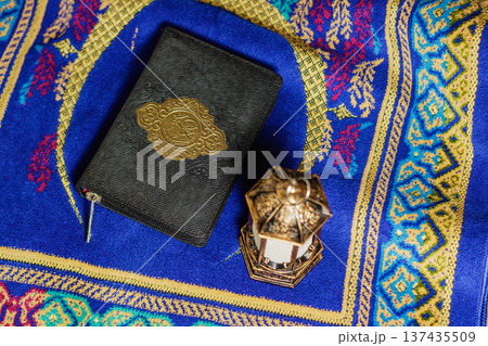 Holy Quran Book and Traditional Ramadan Lantern on Blue Prayer Rug Flat Lay. Islamic Holiday Greeting for Ramadan Kareem and Eid Mubarak. High quality photo Holy Quran Book and Traditional Ramadan Lantern on Blue Prayer Rug Flat Lay. Islamic Holiday Greeting for Ramadan Kareem and Eid Mubarak. High quality photo 137435509
