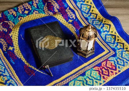 Holy Quran and Traditional Arabic Lantern on Blue Prayer Rug . Islamic Ramadan Kareem and Eid Mubarak Concept. High quality photo 137435510