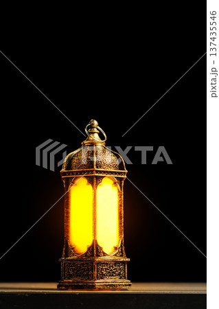 Vintage Ornate Lantern with Warm Glowing Light on Dark Background. Islamic Holiday Greeting for Ramadan Kareem and Eid Mubarak. High quality photo 137435546