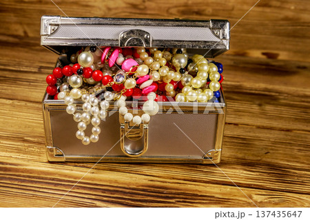 Jewelry box full of jewelry and accessories on wooden background 137435647