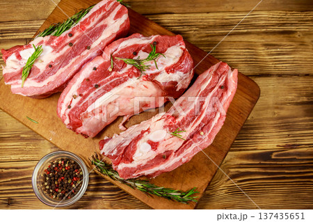Raw pork ribs with spices and rosemary on wooden table. Top view 137435651