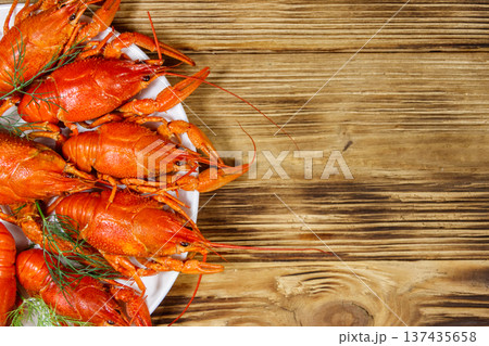 Boiled crayfish in plate on wooden table. Top view 137435658
