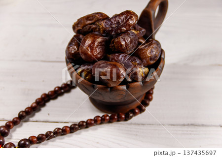 Dates fruit and rosary on white wooden table 137435697