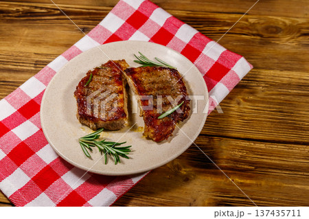 Grilled pork steaks with rosemary on wooden table Grilled pork steaks with rosemary on wooden table 137435711