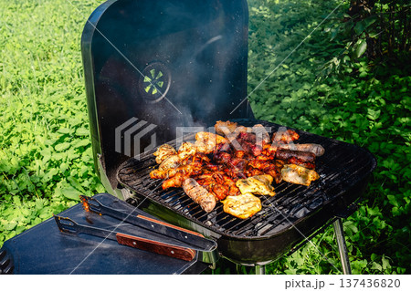 grilled meat over the coals on barbecue 137436820