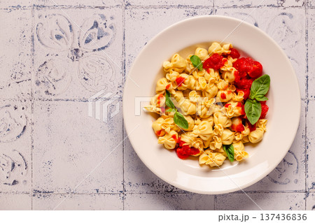 pasta in a plate with tomato sauce. 137436836
