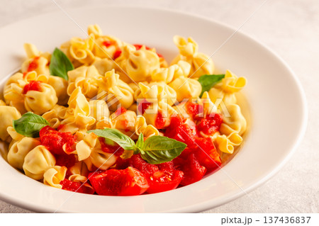 pasta in a plate with tomato sauce. 137436837