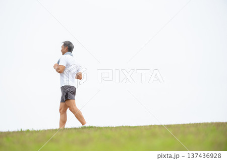 土手を歩く男性　ウォーキング 137436928