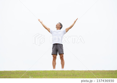 土手で伸びをする男性 土手で伸びをする男性 137436930