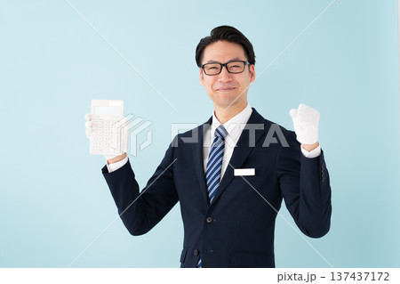 白手袋で計算機を持つ男性 ガッツポーズ 白手袋で計算機を持つ男性 ガッツポーズ 137437172
