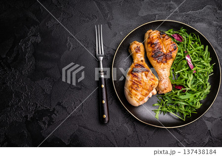 Deliciously grilled chicken legs drumsticks, featuring a crispy skin and juicy meat, a must have for any outdoor feast. black background. top view Deliciously grilled chicken legs drumsticks, featuring a crispy skin and juicy meat, a must have for any outdoor feast. black background. top view 137438184
