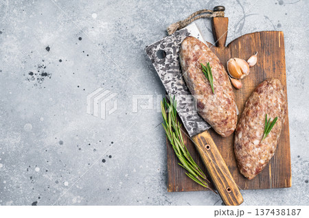 Succulent raw kofta kebab pieces marinated in spices, ideal for grilling enthusiasts looking to elevate their barbecue game. grey background. top view Succulent raw kofta kebab pieces marinated in spices, ideal for grilling enthusiasts looking to elevate their barbecue game. grey background. top view 137438187