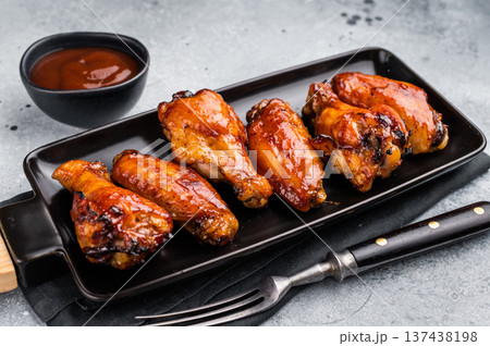 Juicy barbecue chicken wings, perfectly grilled and glazed, ideal for your next summer cookout or party. grey background. top view Juicy barbecue chicken wings, perfectly grilled and glazed, ideal for your next summer cookout or party. grey background. top view 137438198