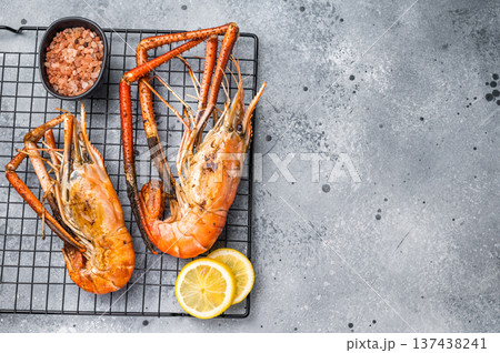 Close up of beautifully grilled rosenbergii prawn, showcasing its smoky glaze and appetizing texture. grey background. top view Close up of beautifully grilled rosenbergii prawn, showcasing its smoky glaze and appetizing texture. grey background. top view 137438241