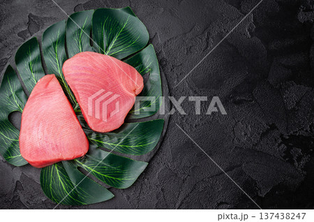 Beautifully cut raw tuna steak, rich in flavor and omega 3s, ready to elevate your culinary creations. black background. top view Beautifully cut raw tuna steak, rich in flavor and omega 3s, ready to elevate your culinary creations. black background. top view 137438247