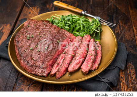 Perfectly grilled Skirt beef steak, highlighting its tenderness and flavorful crust, ideal for meat enthusiasts. wooden background. top view Perfectly grilled Skirt beef steak, highlighting its tenderness and flavorful crust, ideal for meat enthusiasts. wooden background. top view 137438252
