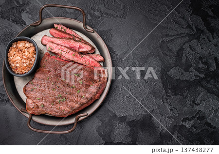Succulent grilled top sirloin steak, cooked to perfection and drizzled with a rich sauce for an unforgettable dining experience. black background. top view 137438277