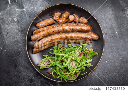 Smoky grilled sausage with grill marks, perfect for satisfying cravings at barbecues and casual dining events. black background. top view Smoky grilled sausage with grill marks, perfect for satisfying cravings at barbecues and casual dining events. black background. top view 137438280