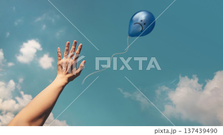 Mind, Mental Health. Hand releasing Blue Sadness Balloon to sky 137439490