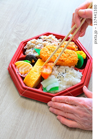 お弁当を持つ手元 137441380