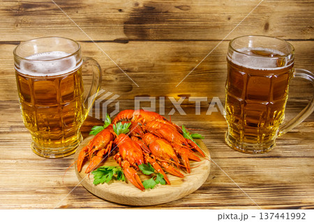 Boiled crayfish and two mugs of beer on a wooden table Boiled crayfish and two mugs of beer on a wooden table 137441992