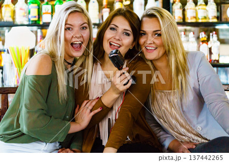 Women in bar singing karaoke 137442265