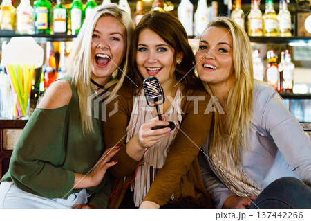 Women in bar singing karaoke 137442266