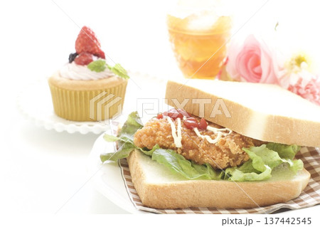 フライドチキンサンドイッチとイチゴカップケーキ フライドチキンサンドイッチとイチゴカップケーキ 137442545
