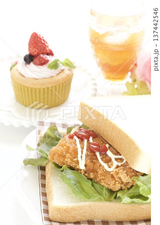 フライドチキンサンドイッチとイチゴカップケーキ フライドチキンサンドイッチとイチゴカップケーキ 137442546