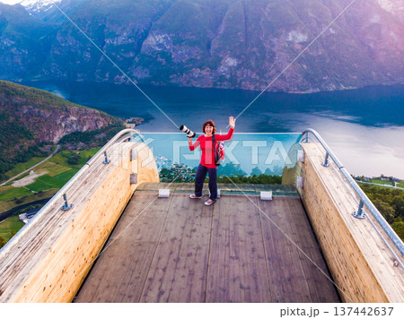 Tourist enjoying fjord view on Stegastein viewpoint Norway Tourist enjoying fjord view on Stegastein viewpoint Norway 137442637