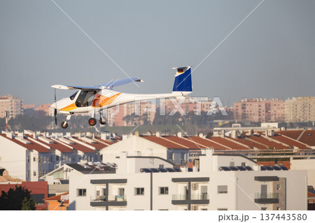 Ultralight aircraft flying over residential city buildings Ultralight aircraft flying over residential city buildings 137443580