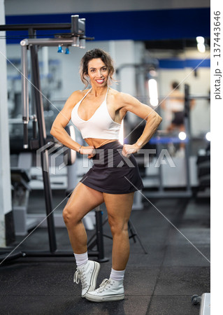 Confident fit woman showing strong physique at gym Confident fit woman showing strong physique at gym 137443646