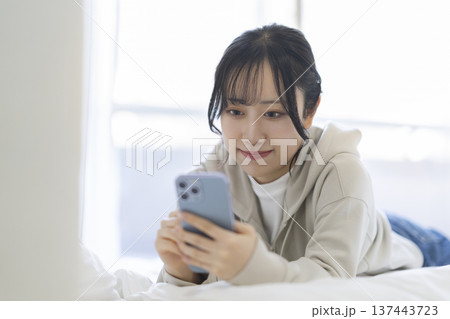 スマートフォンの画面を見つめる若い女性 スマートフォンの画面を見つめる若い女性 137443723