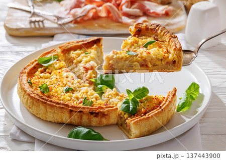 Slice of Quiche Lorraine on a spatula on a plate 137443900