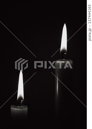 Two burning candles in black and white style, mourning concept or energy blackout background, symbol of memory and light during darkness Two burning candles in black and white style, mourning concept or energy blackout background, symbol of memory and light during darkness 137444165