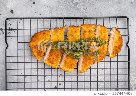 Tender chicken cutlet katsu, coated in crunchy breadcrumbs and fried to perfection. Ideal for a satisfying meal or as a topping for rice. grey background. top view 137444405