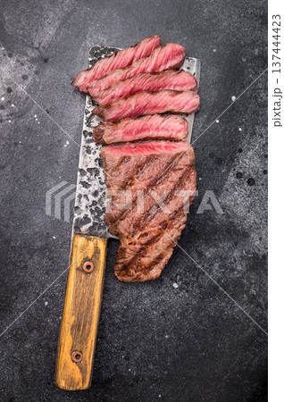 Savory shoulder steak Denver, beautifully cooked on the grill, highlighting its marbled texture and succulent taste. black background. top view Savory shoulder steak Denver, beautifully cooked on the grill, highlighting its marbled texture and succulent taste. black background. top view 137444423