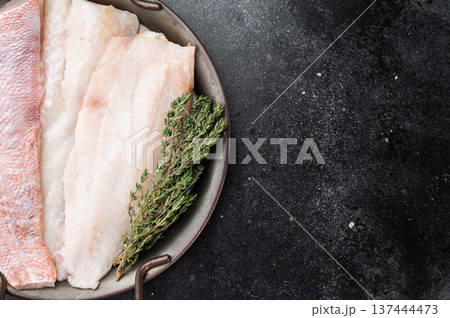 Raw redfish fillets on plate with thyme. Fresh seafood ingredient on dark background with copy space. Raw redfish fillets on plate with thyme. Fresh seafood ingredient on dark background with copy space. 137444473