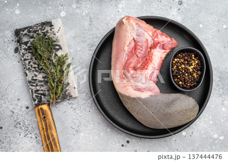 Raw beef tongue meat with spices and herbs on black plate. Traditional offal product used in gastronomy. Raw beef tongue meat with spices and herbs on black plate. Traditional offal product used in gastronomy. 137444476