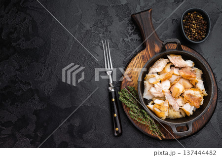 Fried white fish pieces served in small skillet on rustic wooden board with herbs and spices. Fried white fish pieces served in small skillet on rustic wooden board with herbs and spices. 137444482